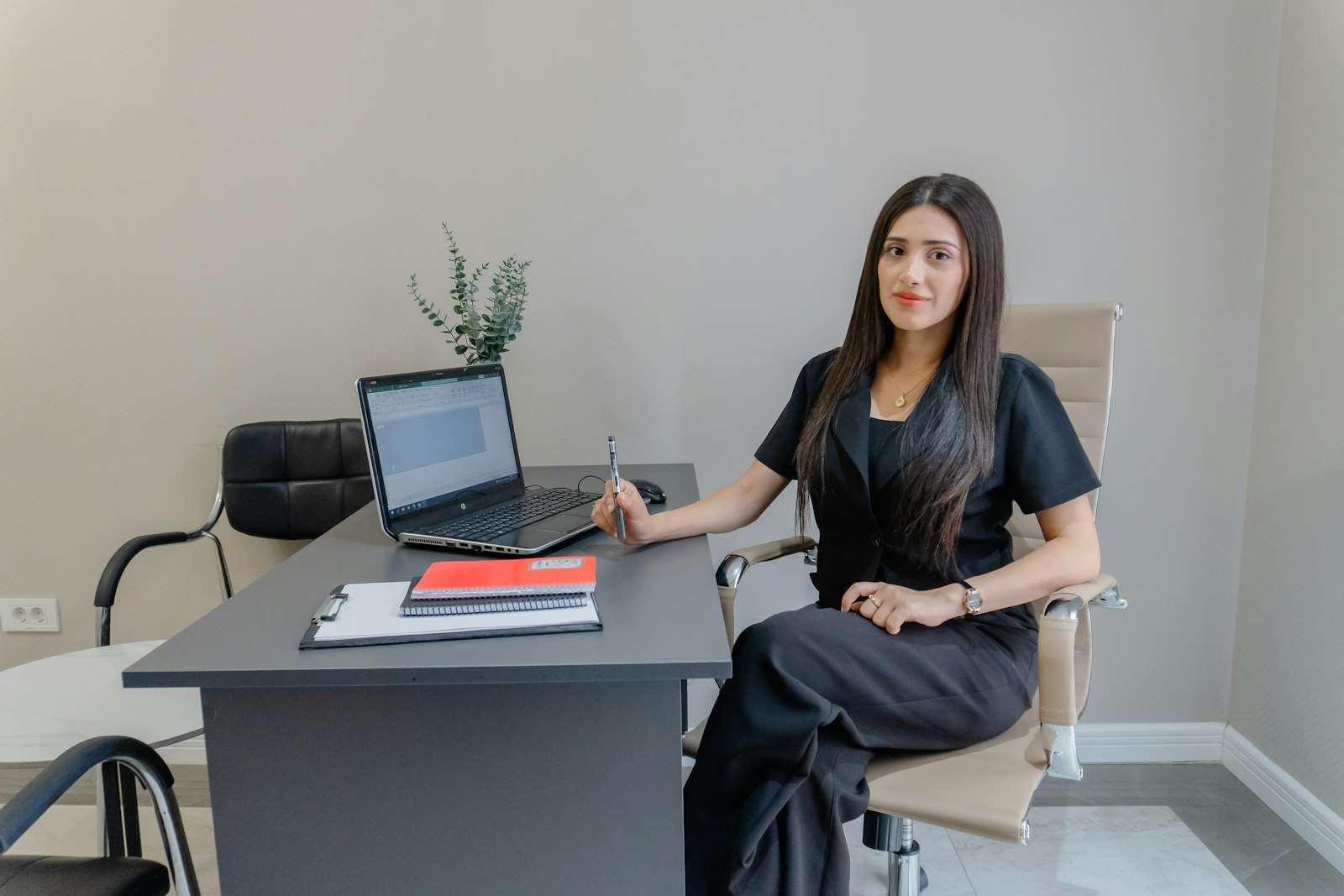 Femme élégante assise à un bureau devant un ordinateur portable, dans une lumière douce